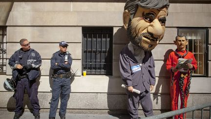 Des officiers de police observent des manifestants d&eacute;guis&eacute;s en Mahmoud Ahmadinejad, le pr&eacute;sident irakien (G) et Bachar&nbsp;Al-Assad, le pr&eacute;sident syrien et post&eacute;s devant l'h&ocirc;tel o&ugrave; loge le leader iranien &agrave; New York (Etats-Unis), le 25 septembre 2012. (ANDREW KELLY / REUTERS)