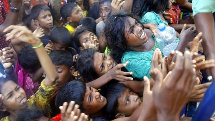 Des réfugiés Rohingyas, le 15 septembre 2017,&nbsp;autour d'un camion livrant des vêtements à Ukhia, au Bengladesh. (SONY RAMANY / NURPHOTO / AFP)