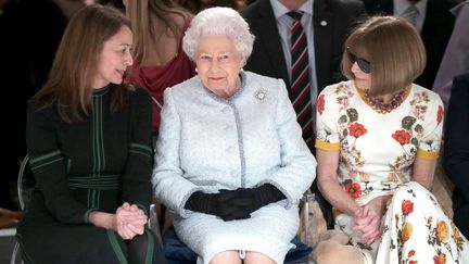 La reine d'Angleterre Elizabeth II, entourée d'Anna Wintour, rédactrice en chef de l'édition américaine de Vogue, et de Caroline Rush du Conseil britannique de la mode (BFC), lors de la Fashion Week de Londres (Royaume-Uni), le 20 février 2018.&nbsp; (YUI MOK / AFP)