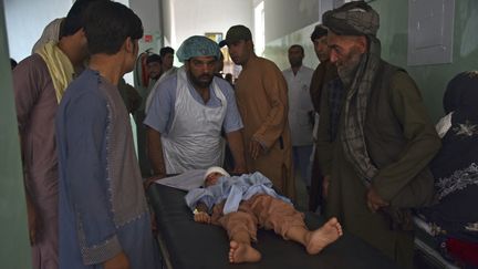 Un enfant blessé est transporté sur une civière vers un hôpital après un attentat à la voiture piégée à Kandahar le 6 juillet 2021 (JAVED TANVEER / AFP)