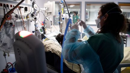 Une soignante du service de réanimation de l'hôpital Louis-Mourier (AP-HP) de Colombes (Hauts-de-Seine) s'occupe d'un patient atteint du Covid-19, le 4 mai 2021. (ALAIN JOCARD / AFP)