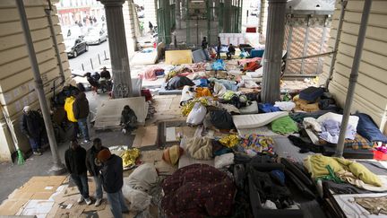 Des migrants discutent sur le campement installé sous le métro aérien de Stalingrad, le 23 mars 2016, à Paris.&nbsp; (JOEL SAGET / AFP)