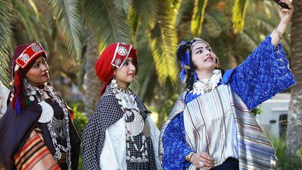 Le "petit costume" de qualité inférieure est composé de multiples tissus de couleurs vives et paré de nombreux bijoux. (MAHMUD TURKIA / AFP)