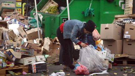 Une personne r&eacute;cup&egrave;re de la nourriture sur le march&eacute; de Belleville, le 26 mai 2009 &agrave; Paris. (JOEL SAGET / AFP)