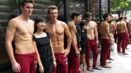 Des vendeurs de la marque Abercrombie &amp; Fitch posent devant une boutique de Singapour, le 14 d&eacute;cembre 2011. (CLARO CORTES / REUTERS)