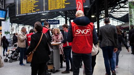 Des employ&eacute;s de la SNCF renseignent des voyageurs lors&nbsp;de la journ&eacute;e de gr&egrave;ve du 1er juin 2016, &agrave; la gare Saint-Lazare, &agrave; Paris. (RODRIGO AVELLANEDA / ANADOLU AGENCY / AFP)