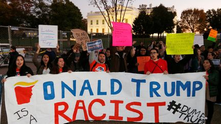 "Donald Trump raciste" peut-on lire sur cette pancarte brandie par des manifestants devant la Maison Blanche, le jeudi 10 novembre, à Washington.&nbsp; (KEVIN LAMARQUE / REUTERS)