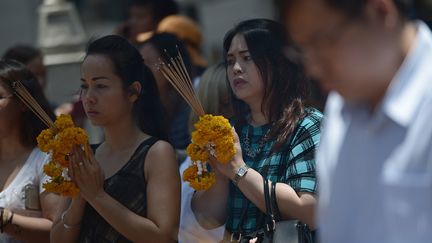 Des personnes prient lors de la r&eacute;ouverture&nbsp;du sanctuaire vis&eacute; par un attentat &agrave; Bangkok (Tha&iuml;lande), le 19 ao&ucirc;t 2015. (CHRISTOPHE ARCHAMBAULT / AFP)