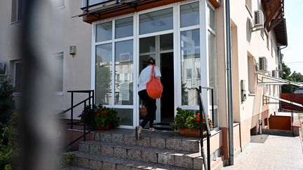 Une femme entre au siège de l'entreprise BAC Consulting, à Budapest (Hongrie), le 18 septembre 2024. L'entreprise hongroise est pointée du doigt après l'explosion des bipeurs au Liban. (ATTILA KISBENEDEK / AFP)