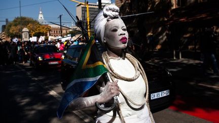 Une femme vêtue d'une robe de mariée tient un drapeau sud-africain lors d'une marche organisée le 20 mai 2017 à Pretoria contre les violences faites aux femmes.  (WIKUS DE WET / AFP)