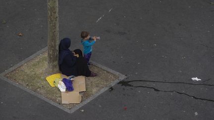 Une femme sans-abri et un enfant dans la rue, à Paris. (JOEL SAGET / AFP)