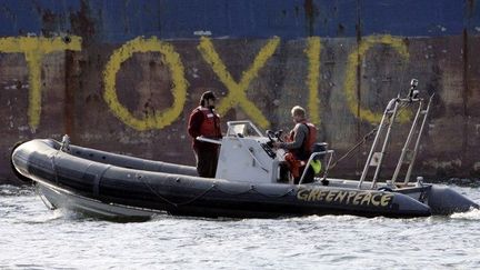 Militants de Greenpeace devant la coque du «Probo Koala», immobilisé en Estonie en septembre 2006. Le navire est accusé d'avoir déchargé des produits toxiques en Côte d'Ivoire, faisant 17 morts. (RAIGO PAJULA / AFP)