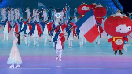 La délégation française de 18 athlètes fait son apparition au sein du "Nid d'Oiseau", menée par son porte-drapeau, le biathlète et fondeur Benjamin Daviet.
