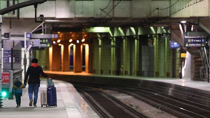 Un enfant accompagné d'un adulte sur le quai de la gare Montparnasse, à Paris, le 11 décembre 2019. (ALAIN JOCARD / AFP)