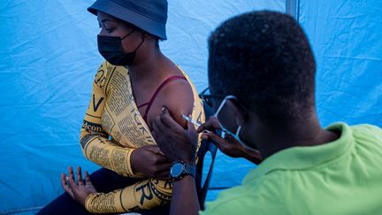 Une patiente se fait vacciner contre le Covid-19&nbsp;à Johannesburg, le 8 décembre 2021.&nbsp; (EMMANUEL CROSET / AFP)