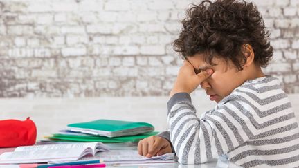 Un enfant devant ses devoirs (CHASSENET / BSIP)