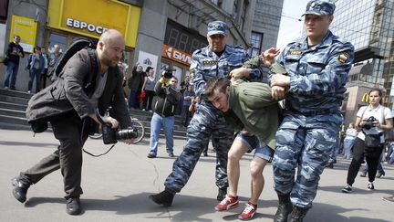 Des agents du minist&egrave;re de l'Int&eacute;rieur arr&ecirc;tent un opposant &agrave; l'investiture de Vladimir Poutine, le 7 mai 2012, &agrave; Moscou (Russie).&nbsp; (DENIS SINYAKOV / REUTERS)