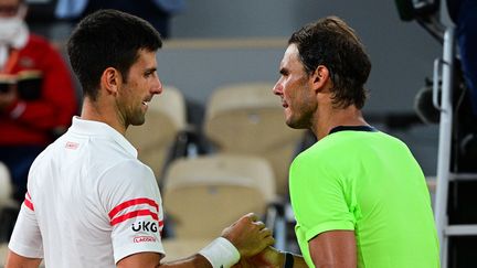 La poignée de mains entre deux monstres à l'issue de leur 58e duel sur le circuit, l'un des plus beaux entre Rafael nadal et Novak Djokovic en demi-finale de Roland-Garros le 11 juin 2021. (MARTIN BUREAU / AFP)