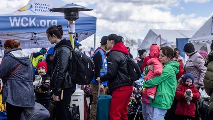 Des réfugiés ukrainiens attendent le bus après avoir traversé la frontière ukraino-polonaise au poste frontière de Medyka, dans le sud-est de la Pologne, le 8 avril 2022. (WOJTEK RADWANSKI / AFP)