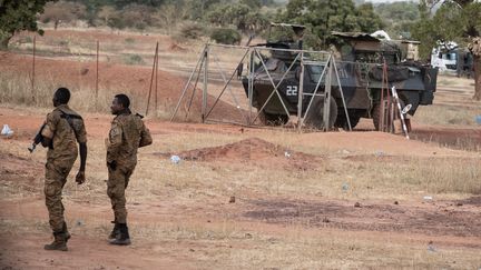 Des militaires burkinabè patrouillent près d'un véhicule militaire français stationné à Kaya (Burkina Faso), le 20 novembre 2021. (OLYMPIA DE MAISMONT / AFP)