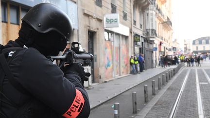 Un policier pointe un lanceur de balles de défense (LBD) lors d'une manifestation des "gilets jaunes" à Bordeaux, le 2 mars 2019. (MEHDI FEDOUACH / AFP)