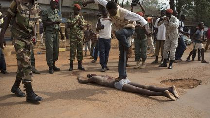 Un homme saute sur le cadavre d'un homme tu&eacute; par la foule qui l'accusait d'avoir rejoint les rebelles S&eacute;l&eacute;ka &agrave; Bangui (Centrafrique), le 5 f&eacute;vrier 2014. (SIEGFRIED MODOLA / REUTERS)