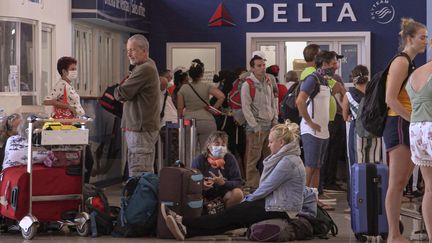 Des touristes patientent à l'aéroport de La Havane (Cuba), le 24 mars 2020. (ADALBERTO ROQUE / AFP)