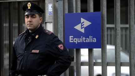 Un policier devant l'agence Equitalia o&ugrave; un colis pi&eacute;g&eacute; a explos&eacute;, le 9 d&eacute;cembre 2011 &agrave; Rome (Italie).&nbsp; (FILIPPO MONTEFORTE / AFP)