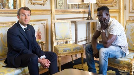 Emmanuel Macron et Mamadou Gassama, le sans-papiers qui a sauvé un enfant suspendu dans le vide à Paris, le 28 mai 2018 à l'Elysée. (JACQUES WITT / SIPA)