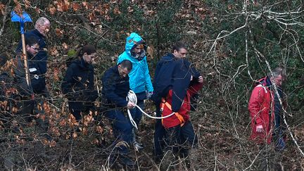 Hubert Caouissin (au centre, caché) et son avocat, lors d'une première reconstitution des meurtres de la famille Troadec, le 12 mars 2019, à&nbsp;Pont-de-Buis (Finistère). (FRED TANNEAU / AFP)