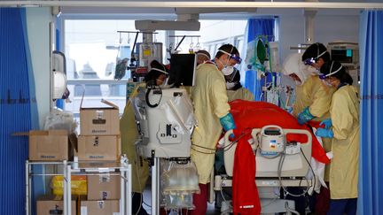 Des soignants prennent en charge un malade du Covid-19, le 23 mars 2021, à l'hôpital de&nbsp;Portsmouth, au Royaume-Uni. (ADRIAN DENNIS / AFP)