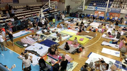 Des personnes évacuées de leur maison s'abritent dans la salle de sport Venetoklio en raison des incendies de forêt sur l'île de Rhodes, en Grèce, le 23 juillet 2023. (DAMIANIDIS ELEFTHERIOS / ANADOLU AGENCY / AFP)