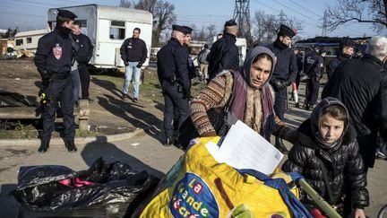 Des Roms quittent leur campement apr&egrave;s leur expulsion par la police, le 5 mars 2014 &agrave; Lyon (Rh&ocirc;ne). (JEFF PACHOUD / AFP)