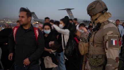 Des Afghans quittent Kaboul avec l'aide de militaires français avant d'atterir à Paris. (- / AFP)