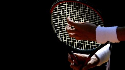 Un joueur de tennis ajustant sa raquette à Rome en 2005 (illustration). (PAOLO COCCO / AFP)