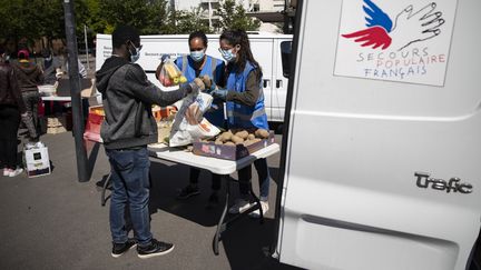 Des bénévoles du Secours populaire distribuant de la nourriture et des produits d'hygiène aux étudiants précaires, le 6 mai 2020 à Saint-Denis en région parisienne. (THOMAS SAMSON / AFP)