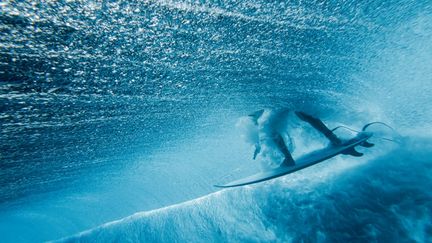 L'Américain Griffin Colapinto s'engouffre dans un tube, à Teahupo'o, lors d'une séance d'entraînement, le 22 juillet 2024. (BEN THOUARD / AFP)