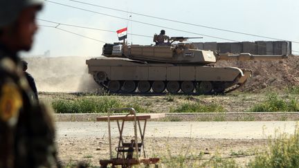 Un char irakien roule dans un champ situ&eacute; &agrave; l'ouest de Tikrit (Irak), le 11 mars 2015, au cours d'une op&eacute;ration lanc&eacute;e pour reprendre la ville aux jihadistes de l'Etat islamique.&nbsp; (AHMAD AL-RUBAYE / AFP)