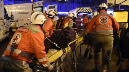 Des secouristes évacuent un blessé des attentats, le 13 novembre 2015 à Paris. (DOMINIQUE FAGET / AFP)