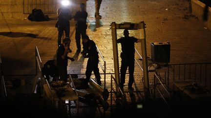 Les forces de sécurité israéliennes retirent des portiques de sécurité, le 25 juillet 2017, devant une entrée de l'esplanade des Mosquées, à Jérusalem. (AHMAD GHARABLI / AFP)