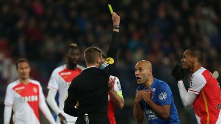 L'arbitre Clément Turpin donne un carton jaune au défenseur brésilien Fabinho et au défenseur français Ala eddine Yahia pendant le match Caen-Monaco en Ligue 1, le 4 mars 2016 à Caen.&nbsp; (CHARLY TRIBALLEAU / AFP)