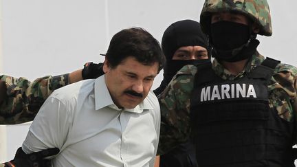 Joaquin "el Chapo" Guzman est escort&eacute; par des soldats sur une base militaire, &agrave; Mexico, apr&egrave;s son arrestation, le 22 f&eacute;vrier 2014.&nbsp; (HENRY ROMERO / REUTERS )