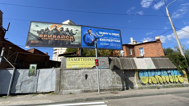 Une affiche encourageant les candidatures pour la brigade Azov, dans les rues de Kharkiv (Ukraine). (RAPHAEL GODET / FRANCEINFO)