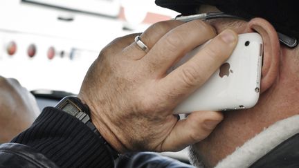 Une personne t&eacute;l&eacute;phone avec un iPhone, le 4 janvier 2012, &agrave; Lyon (Rh&ocirc;ne). (JEAN-PHILIPPE KSIAZEK / AFP)