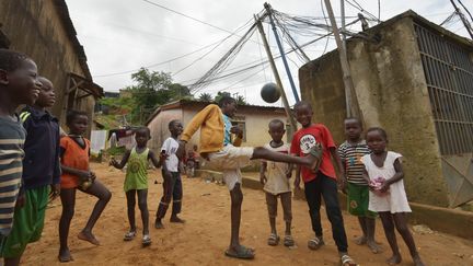 Des enfants jouent au football dans un quartier d'Abidjan, en Côte d'Ivoire. (SIA KAMBOU / AFP)