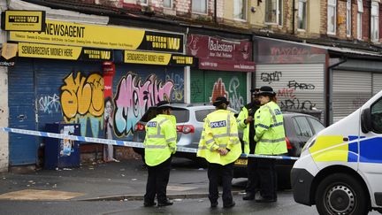 Des policiers inspectent les lieux de la fusillade survenue quelques heures plus tôt, dimanche 12 août à Manchester (Royaume-Uni). (OLI SCARFF / AFP)