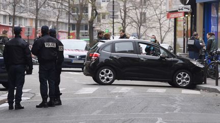 Des policiers se tiennent &agrave; c&ocirc;t&eacute; d'une voiture utilis&eacute;e dans leur fuite par les hommes qui ont attaqu&eacute; le si&egrave;ge de "Charlie Hebdo", &agrave; Paris, le 7 janvier 2015. (DOMINIQUE FAGET / AFP)