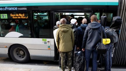 Des passagers tentent de monter à bord d'un bus de la RATP, le 18 février 2022, à Paris, lors d'une journée de grève. (LUDOVIC MARIN / AFP)