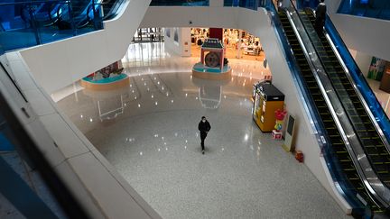 Un passant dans un centre commercial vide, le 5 mars 2020 à Pékin (Chine). (AFP)