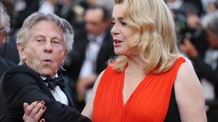 Catherine Deneuve serait-elle en train de retenir Roman Polanski ? Lui semble en tout cas prêt à détaler. 
 (Valéry Hache / AFP)